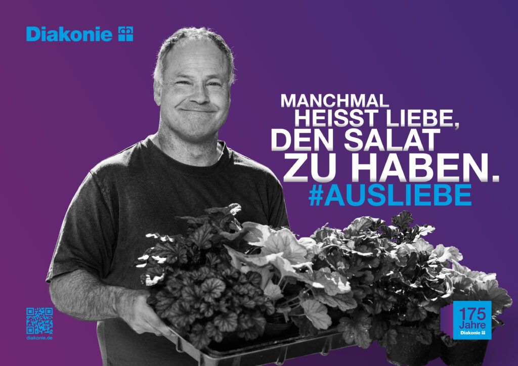 Plakatmotiv Jubiläumskampagne: Lächelnder Mann mit Salatkorb: Manchmal heißt Liebe, den Salat zu haben.#ausLiebe